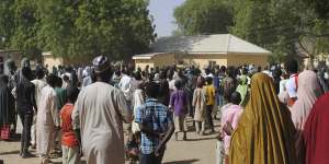 People gather outside the hospital where the released girls were being treated in Dapchi.