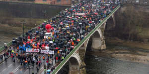 Demonstrators march across the Pont des Catalans in Toulouse during a national strike against pension reform in France.