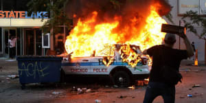 A Chicago police vehicle is set on fire during violent protests Saturday,May 30,2020,as outrage builds over the killing of George Floyd,a black man who died in Minneapolis on May 25 after a police officer pressed his knee into his neck for several minutes. (Ashlee Rezin Garcia/Chicago Sun-Times via AP)