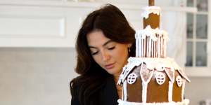 Ginger bread house architect Rebecca Lauren with one of her $2500 Christmas creations.