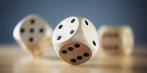 Rolling three dice on a wooden desk die dice?