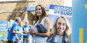 Much in common but only one victor:Jacqui Scruby on polling day,flanked by the poster of her Liberal rival,Georgia Ryburn.