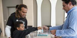 A boy helps his father to vote in New Caledonia's second independence referendum. 