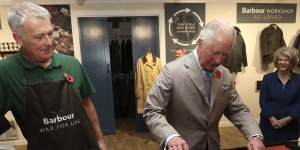 Then Prince Charles has a go at reproofing a jacket during a visit to Royal Warrant Holder,J Barbour And Sons in 2021.