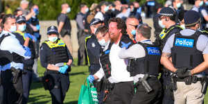 A man is taken away by police at the Shrine of Remembrance. 