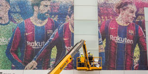 An image of Lionel Messi is removed from Camp Nou,Barcelona’s home stadium,after his move to Paris was confirmed.