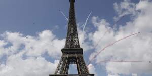The elite aerial acrobatic team,Patrouille de France,fly by the Eiffel Tower in Paris on Sunday to celebrate the handover of the Olympic flag to the city that will host the 2024 Games.