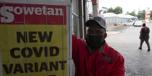 A petrol attendant stands next to a newspaper headline in Pretoria,South Africa on Saturday.