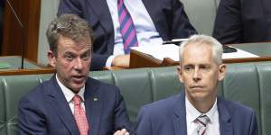 Opposition immigration spokesman Dan Tehan (left) and Immigration Minister Andrew Giles discuss the bill with Prime Minister Anthony Albanese (facing away from camera) on Tuesday.