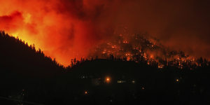 The McDougall Creek wildfire burns on the mountainside above houses in West Kelowna,Canada,in August.
