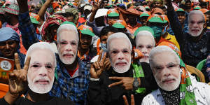 Bharatiya Janata Party (BJP) supporters wear masks of Prime Minister Narendra Modi.