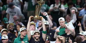 The Boston Celtics’ Jayson Tatum lifts the Larry O’Brien Championship Trophy.