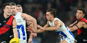 Zach Merrett handballs for the Bombers in their nailbiting win over the Kangaroos.