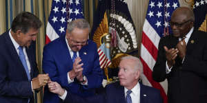 President Joe Biden hands the pen he used to sign the Democrats’ landmark climate change and health care bill to Senator Joe Manchin. Also pictured is Senate Majority Leader Chuck Schumer and Majority Whip James Clyburn.