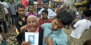 A woman holds a picture of her son,who went missing in the Rana Plaza building collapse in 2013 in Bangladesh.