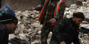 Civil defence workers and security forces search through the wreckage of collapsed buildings,in Hama,Syria.