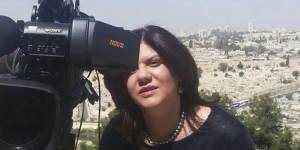 In this undated photo provided by al-Jazeera,Shireen Abu Akleh stands next to a TV camera in Jerusalem.