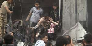 Palestinians rescue a woman from a destroyed building following Israeli airstrikes in Khan Younis refugee camp,southern Gaza Strip.