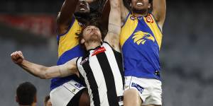 Nic Naitanui and Jack Petruccelle attempt to mark over Jordan Roughead of the Magpies.