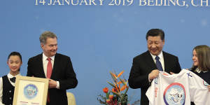 Finnish President Sauli Niinisto and Chinese President Xi Jinping receive T-shirts at the 2019 China-Finland Year of Winter Sports at the Great Hall of the People in Beijing.