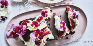 Chocolate loaf cake topped with mascarpone icing,red jam and flowers.