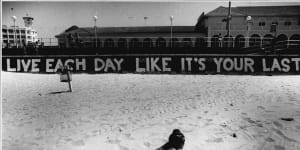 A beach goer takes the graffiti to heart at Bondi,29 October,1990.
