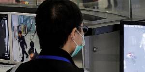 A health surveillance officer monitors passengers arriving at the Hong Kong International airport.