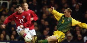 Craig Moore gets a tackle in on England debutant Wayne Rooney.