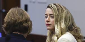 Actor Amber Heard speaks to her attorney.