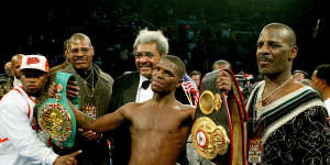 Cory Spinks (with belts) poses with his promoter Don King (centre back),uncle Michael (right) and father Leon (left) after the undisputed welterweight championship bout in New Jersey.