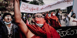 A Buddhist monk raises his clenched fist while marching during an anti-military government protest rally on February 1,2022,in Mandalay,Myanmar. 