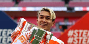 Dougall holds up the trophy after Blackpool’s promotion.