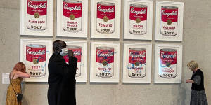 Protesters glue themselves to Warhol Campbell’s Soup display at the National Gallery of Australia.