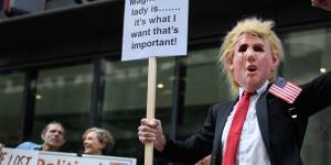 A man wears a Donald Trump mask as supporters of the Wikileaks founder Julian Assange gather outside the Old Bailey on September 14.