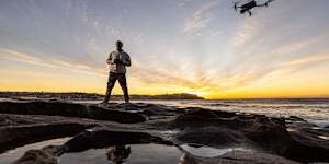 Jason Iggledon flying his drone on the rocks at the southern end of Bondi Beach.