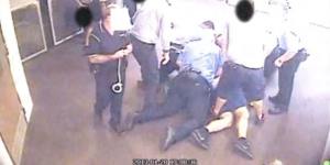 A still from CCTV footage of a young person being held on the ground in a Queensland youth detention centre,contained in a report.