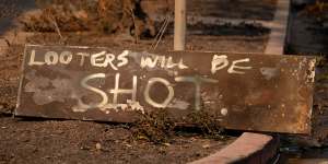 A homemade sign sits on the ground near homes destroyed by the Palisades fire in Los Angeles.