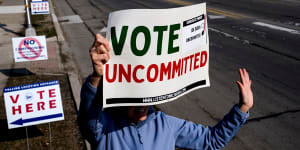 A volunteer holds a sign outside a polling station at Oakman School in Dearborn,Michigan.
