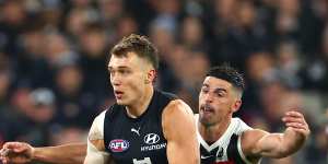 Patrick Cripps is chased down by Scott Pendlebury.