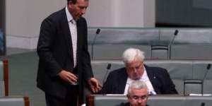 Mal Brough offers a glass of water to Clive Palmer during question time.