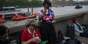 Vanessa,Anne and Grace,from left to right,have breakfast as they wait opposite the Palace of Westminster.