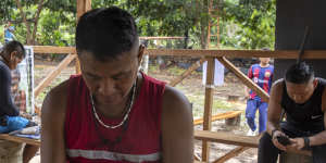 Marubo people use their phones,bought in the closest city,when the Starlink antenna is turned on in their village,in Manakieaway,Brazil.