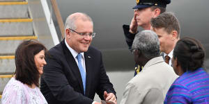 Prime Minister Scott Morrison and his wife Jenny greet Solomon Islands Prime Minister Manasseh Sogavare (right) after arriving in the Solomon Islands on Sunday.