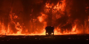 Firefighters overwhelmed by flames at a bushfire in Orangeville,west of Campbelltown.