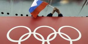 A Russian flag is held above the Olympic Rings at Adler Arena Skating Centre during the Winter Olympics in Sochi,Russia in 2014. 