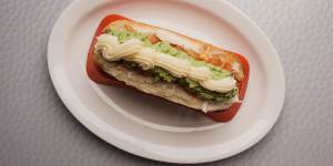 The deluxe dog is topped with tomato,avo,sauerkraut and mayo. 