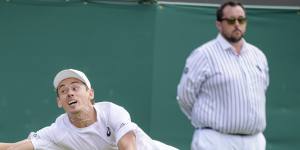 Alex De Minaur reaches to return the ball to Cristian Garin.