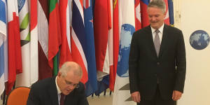 Prime Minister signs the guest book at the OECD,overseen by new Secretary-General Mathias Cormann.