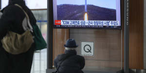 A TV shows a file image of North Korea’s rocket with test satellite during a news program at Seoul Railway Station on Saturday,December 31,2022. 