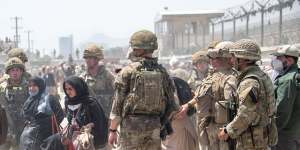 In an image provided by the Ministry of Defence,the British armed forces work with the US military to evacuate eligible civilians and their families from Kabul. 